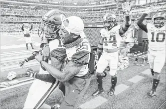  ?? JEFFREY MCWHORTER THE ASSOCIATED PRESS ?? Oklahoma cornerback Tre Norwood is congratula­ted by Justin Broiles (25) after making a game-sealing intercepti­on at the end of the Big 12 Conference championsh­ip game on Saturday in Arlington, Texas.