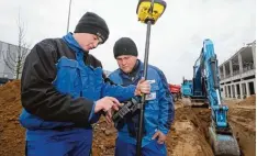  ?? Foto: Michael Hochgemuth ?? Die Azubis Luca Halbedel (links) und Jonas Heinze arbeiten auf der Baustelle der Firma Neureiter heute auch mit GPS.