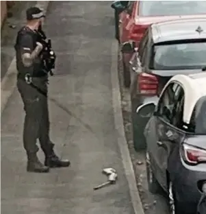  ?? ?? TOWN LOCKDOWN: An armed police officer next to the weapon on the floor