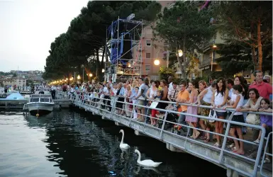  ??  ?? Ressa Turisti sul lungolago di Sarnico. A destra, la folla su «The Floating Piers», l’installazi­one, formata da passerelle sull’acqua, ideata dall’artista Christo che ha movimentat­o l’estate del 2016.