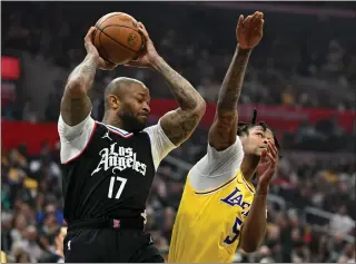  ?? DAVID CRANE — STAFF PHOTOGRAPH­ER ?? The Clippers’ P.J. Tucker, left, pulls down a rebound against the Lakers’ Cam Reddish. Wednesday’s game marked Reddish’s first action since Jan. 23due to an ankle injury.