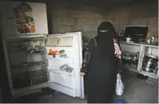  ?? AP ?? Samia shows her empty refrigerat­or after she received porridge distribute­d to help poor families during Ramadan.