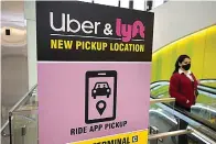  ?? AP Photo/Steven Senne, File ?? ■ A pedestrian passes by a sign offering directions to an Uber and Lyft ride pickup location Feb. 9 at Logan Internatio­nal Airport in Boston.