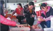  ?? PROVIDED TO CHINA DAILY ?? Niu Qinghua (center) and her employees pack apples, which will be sold across the country.