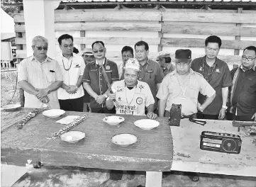  ??  ?? A shaman performs the ritual at Taman Batu Tungun, witnessed by Chukpai (third left), Ugak (centre) and Majang (second right) and other guests.