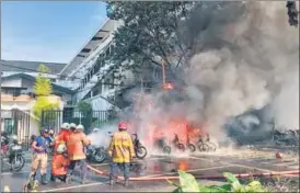  ?? REUTERS ?? Firefighte­rs extinguish a blaze caused by a blast at the Pentecost Church Central Surabaya.