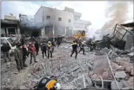  ?? (AFP) ?? Members of the Syrian Civil Defence, also known as the White Helmets, extinguish a fire at the site of a regime airstrike in Syria’s last major opposition bastion of Idlib on Wednesday.