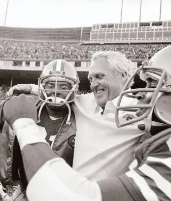  ?? Carl Viti / Associated Press 1981 ?? Coach Bill Walsh is hugged by running back Walt Easley (left) and cornerback Ronnie Lott after the 49ers beat the New York Giants at Candlestic­k Park to clinch the NFC West title.