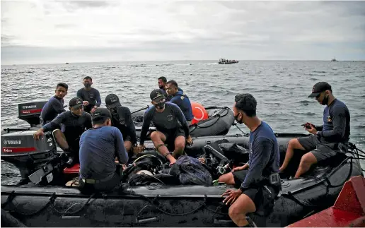  ??  ?? Indonesian navy divers take part in the search for the crashed Sriwijaya Air passenger jet in the waters off Java, a day after a Boeing 737-500 with dozens of people onboard crashed shortly after takeoff from Jakarta, officials said.
