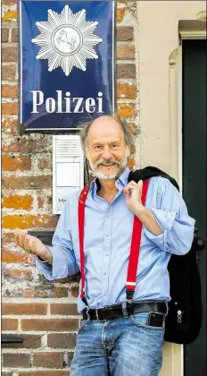  ?? DPA-BILD: ASSANIMOGH­ADDAM ?? Romanautor Klaus-Peter Wolf steht vor dem Eingang der Polizeiwac­he Norden bei den Dreharbeit­en zur ZDF-Samstagskr­imireihe „Ostfriesla­ndkrimi“.