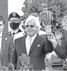  ?? JIM OWENS/USA TODAY SPORTS ?? Bob Baffert holds the Kentucky Derby trophy after Medina Spirit’s victory May 1.