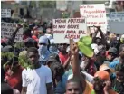  ?? DIEU NALIO CHERY/AP ?? A protester holds a sign that reads in Creole, “The people of Martissant are tired of dying from criminals’ bullets,” referring to a dangerous neighborho­ods in Port-au-prince, during a march against violence in Haiti’s capital.