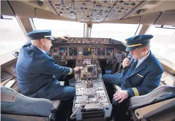  ?? CLIFF OWEN/ASSOCIATED PRESS ?? Capt. Tommy Holloman, left, and Capt. Chuck Stewart on Tuesday demonstrat­e radio communicat­ions, right, and the Data Communicat­ions Data Comm technology, left, from the cockpit of an United Airlines Boeing 777 at Dulles Internatio­nal Airport Air...