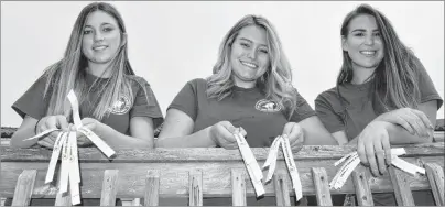  ?? SHARON MONTGOMERY-DUPE/CAPE BRETON POST ?? Coal Dust Days festival co-ordinators, from left, Rebecca Antle, 18, Morgan Donohue, 20 and Amy Walzak, 20, all of New Waterford, show wrist bands for this year’s Coal Dust Days Tavern Tour, one of the new measures put in place to ensure no underage drinking takes place.