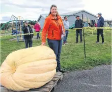  ?? NICOLE SULLIVAN • CAPE BRETON POST ?? Lois MacNeil, one of the many growers who help run the annual Joe King Memorial Giant Pumpkin Weigh-In, shows off her entry before the start of the event. Her monster weighed 718 pounds, which she was happy with but it didn’t beat her personal best which was 875 pounds.