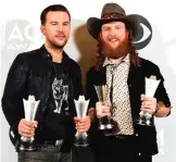  ??  ?? TJ Osborne, left, and John Osborne, of Brothers Osborne, pose in the press room with their awards for Vocal Duo of the year, and new Vocal/Duo Group of the year.