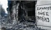  ?? LIBKOS / AP ?? The city center is seen damaged by Russian shelling Friday in Bakhmut, Ukraine. The writing on the wall reads “Bakhmut loves Ukraine.”