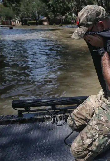  ??  ?? Wes Higgins wipes sweat from his face as he finishes the last of five days of patrolling floooded neighborho­ods in his boat on Thursday. Higgins, from Knott, organized a volunteer team of 10 boats to help Houston residents.