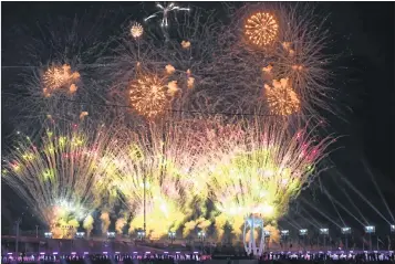  ??  ?? Fireworks light the sky over the Olympic flame during the closing ceremony on Sunday.