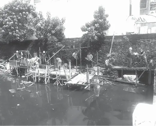  ?? JOY TORREJOS ?? Members of the Mandaue City demolition team dismantle illegal structures along the Mahiga Creek.