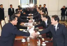  ?? REUTERSPIX ?? South and North Korean (left) delegation­s greet each other at the truce village of Panmunjom yesterday.