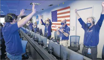  ?? BILL INGALLS/NASA ?? Members of NASA’s Perseveran­ce rover team react Thursday in mission control at NASA’s Jet Propulsion Laboratory in Pasadena, California, after receiving confirmati­on the spacecraft successful­ly touched down on Mars.