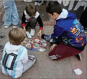  ??  ?? Dans certaines écoles, les albums Panini du Mondial sont interdits.