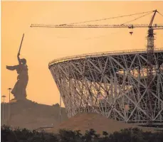  ?? FOTO: DPA ?? Die Mutter-Heimat-Statue (li.) soll an die Gräuel der Schlacht von Stalingrad erinnern. Die Wolgograd-Arena eröffnet zur Fußball-WM.