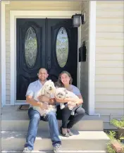  ?? PHOTO COURTESY OF ARTHUR GRIJALVA ?? Arthur Grijalva and his wife, Michelle Moraveg, hold their dogs, Otis and Calical, at their new home in Burbank.