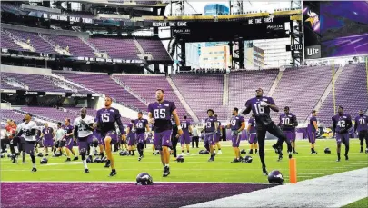  ?? JEAN PIERI/ PIONEER PRESS ?? Vikings players stretch before their first practice at U.S. Bank Stadium in Minneapoli­s on Friday. The Vikings will face the Chargers in a preseason game Sunday, the first for the team at their new stadium.