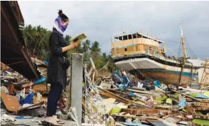  ??  ?? A woman visits an area hit by the tsunami on the coastline in Palu, Central Sulawesi, Indonesia.