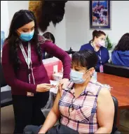  ?? Brian Porter / Fort Morgan Times ?? Magdalena Villarreal, seated, receives her first of a twocourse Moderna COVID-19 vaccinatio­n from Mariana Chavez, a community health worker with the Northeast Colorado Health Department, in April.