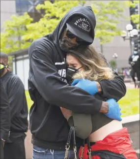  ?? Stephen Maturen / Getty Images ?? Former NBA player Stephen Jackson hugs a woman after speaking at a protest outside the Hennepin County Government Center on Friday in Minneapoli­s. Protests in Minnesota and around the country have been ongoing since George Floyd’s death on Monday.