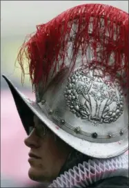  ?? PIER PAOLO CITO — THE ASSOCIATED PRESS ?? FILE — In this file photo, color runs from the feathered helmet of a Swiss guard, during a rainy mass in St. Peter’s Square at the Vatican. The world’s oldest standing army is getting some new headgear. The Swiss Guards plan to replace their metal...