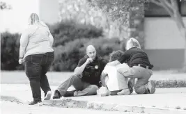  ?? IAN MAULE Tulsa World via AP ?? Police talk to a young man on Wednesday as he waits to be reunited with a family member who was evacuated from the scene of a shooting in Tulsa, Okla.
