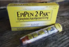  ?? MARK ZALESKI — THE ASSOCIATED PRESS FILE ?? This file photo, shows an EpiPen epinephrin­e auto-injector, a Mylan product, in Hendersonv­ille, Texas. Mylan, now in the crosshairs over severe price hikes for its EpiPen, said Thursday it will expand programs that lower out-of-pocket costs by as much...