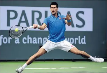  ?? Daniel Murphy European Pressphoto Agency ?? NO. 1 WITH a bullet forehand, Novak Djokovic stretches for a return against Roger Federer in BNP Paribas Open final. The top-ranked Serb battled back after No. 2 Federer’s second-set rally and won, 6-3, 6-7 (5), 6-2.