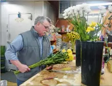  ??  ?? George Fisher works in the back room unpacking flower stems at his store, Fisher Florist, in New London on Monday. Fisher made the decision to work alone under Gov. Ned Lamont’s executive order allowing any business that only has a single occupant or employee to remain open without being designated an essential business.