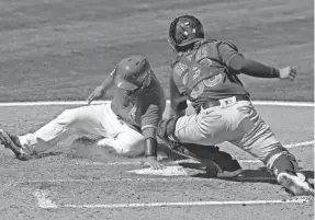  ?? MATT YORK/AP ?? Angels catcher Kurt Suzuki scores ahead of a tag by Cubs catcher P.J. Higgins during a spring training baseball game March 22.