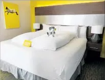  ?? Irene Lechowitzk­y ?? SPLASHES of yellow, individual duvets and a stuffed pooch greet guests at Hotel Z in San Diego’s Gaslamp Quarter.