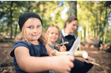  ?? RP-FOTO: RALPH MATZERATH ?? Lisa (l.) und Suri lernen im Monheimer Walkinderg­arten, richtig zu schnitzen. Erzieherin Tatjana Pastor zeigt ihnen, wie’s geht.