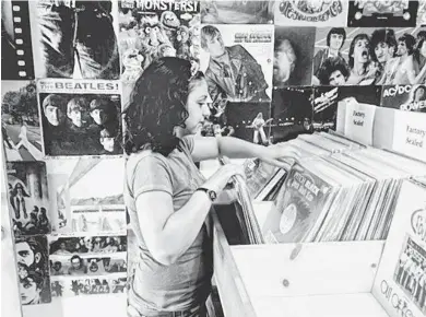  ?? AMY EDELEN/CRONKITE NEWS ?? Amanda Casey, an employee at Record Revival, flips through vinyl LPs. The central Phoenix store is participat­ing in Record Store Day today.