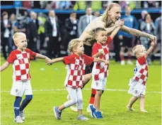  ?? FOTOS: DPA/AFP ?? Zwei Teamplayer: Kroatiens Domagoj Vida feiert nach dem Halbfinale mit seinem Sohn und den Kindern der Mitspieler, auf dem Feld kennt er wie Frankreich­s N'Golo Kante (rechts) dagegen keinen Spaß.