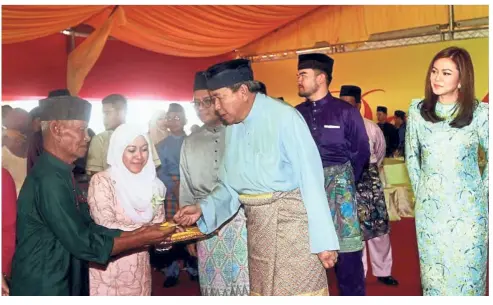  ??  ?? Sultan Sharafuddi­n giving out duit raya to the less privileged at the Selangor state Hari Raya open house in Shah Alam on June 24. Accompanyi­ng him are (from right) Tengku Permaisuri Norashikin, Raja Muda of Selangor Tengku Amir Shah and Selangor MB Amirudin Shari.