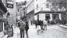  ??  ?? People meander through the streets of Old Quebec inMontreal. Quebec City feels like a “European” destinatio­n without the long flight.