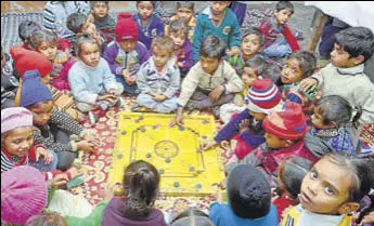  ?? SAMEER SEHGAL/HT ?? Newly enrolled students playing carrom on the floor of a classroom at the government elementary school at Ibban Kalan in Amritsar on Tuesday.