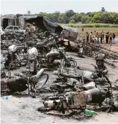  ?? Foto: Iram Asim, AP, dpa ?? Dutzende Motorräder und andere Fahrzeuge liegen verkohlt rund um den Tanklaster im Hintergrun­d. Ihre Besitzer wollten sie auftanken.