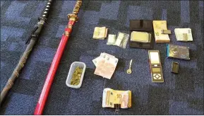  ??  ?? Above: Samuri swords, cash and drugs that were seized in searches of four Killarney properties last week.