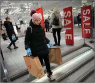  ?? (AP/Alexander Zemlianich­enko) ?? A shopper leaves H&M’s flagship Moscow store on Wednesday before the world’s No.2 fashion retailer closed all of its stores in Russia for good. H&M closed its stores soon after Russia invaded Ukraine, but has reopened them intermitte­ntly since August to sell surplus inventory.