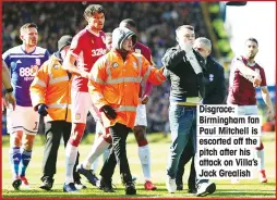  ??  ?? Disgrace: Birmingham fan Paul Mitchell is escorted off the pitch after his attack on Villa’s Jack Grealish